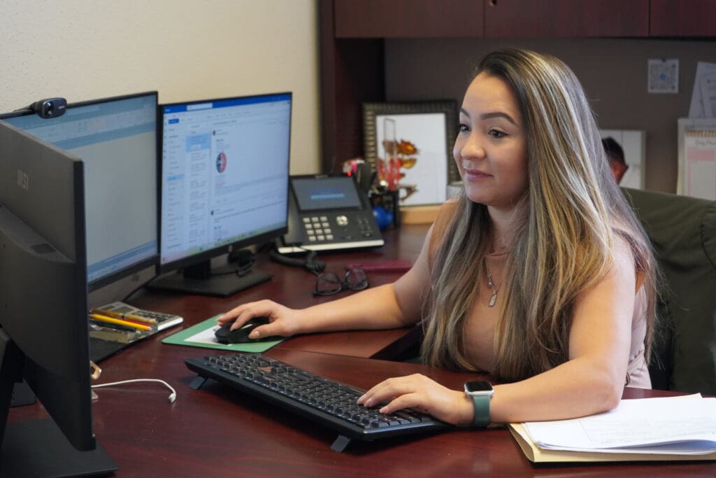 A woman sitting at her desk using a computer.