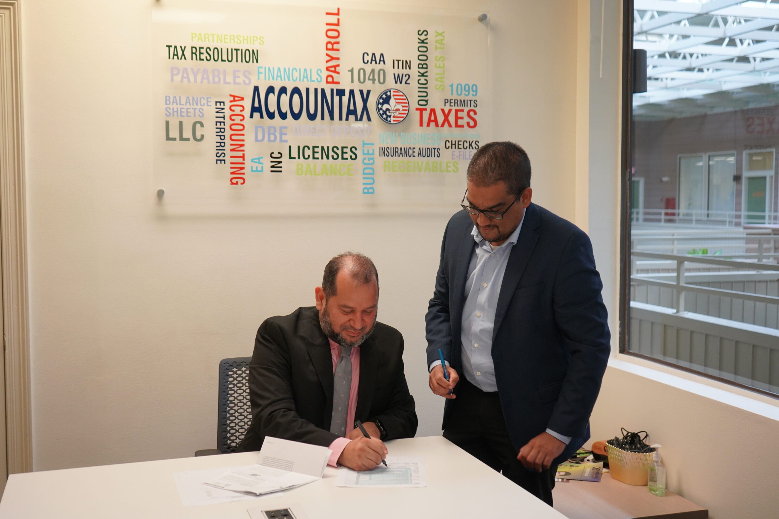 Two men standing at a table with papers.