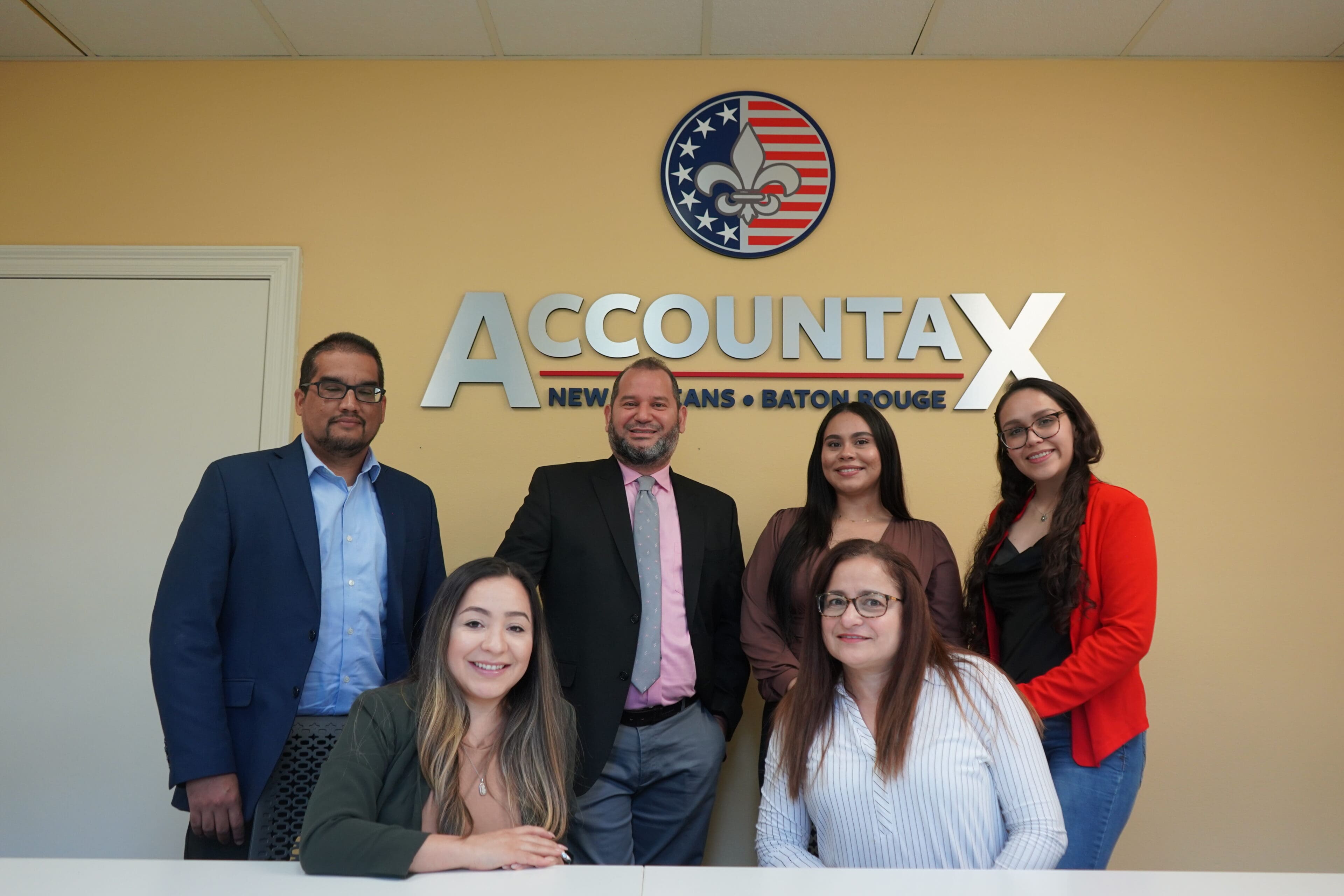 A group of people standing in front of an accountax sign.